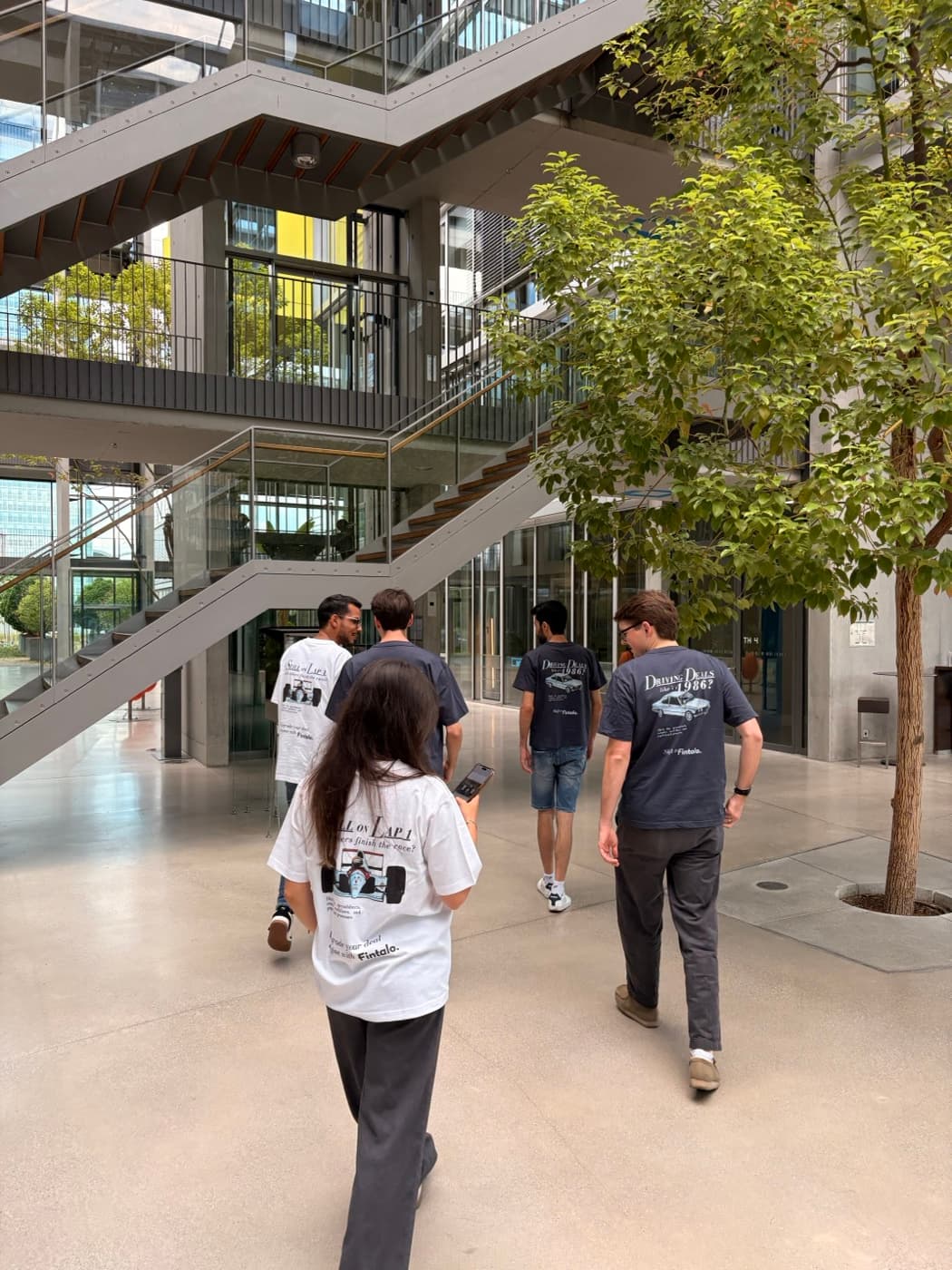 The Fintalo team walking together across an office courtyard, wearing company t-shirts